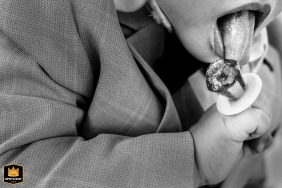   During the ceremony in Zuid Holland, a playful moment unfolds as a young guest can’t resist tasting the ring candy, enjoying the treat in the midst of the celebration.